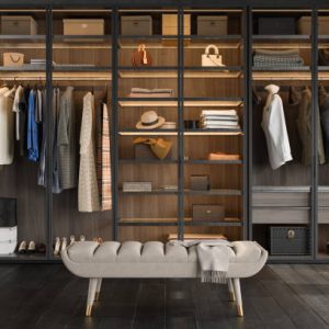 Close-up View Of Walk-in Closet Bench And Wardrobe With Clothes, Boxes, Bags And Shoes